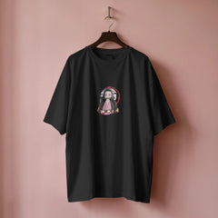 Black t-shirt with a graphic design on a hanger against a pink background