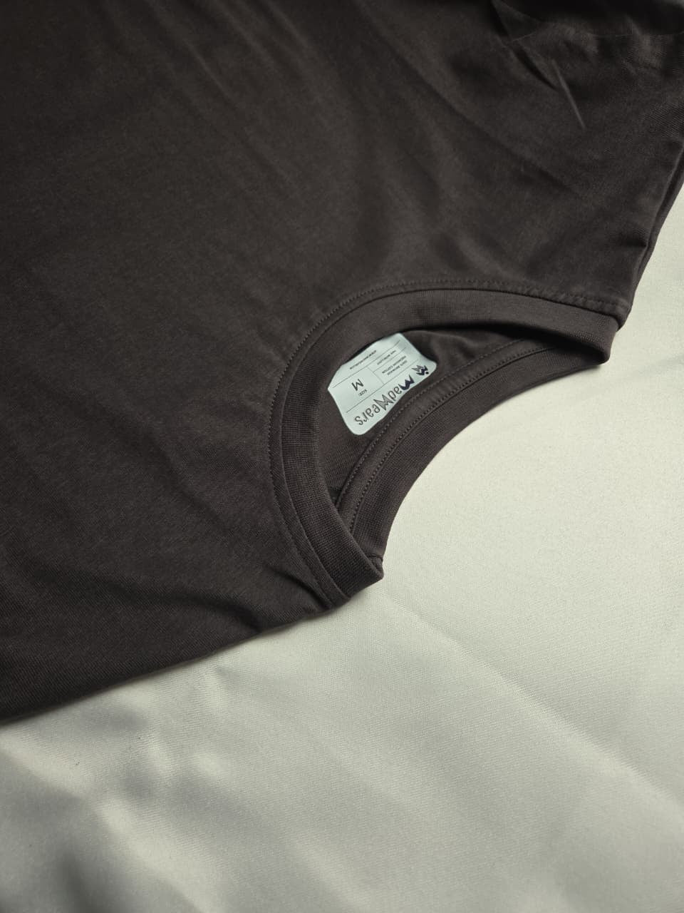 Close-up of a dark brown garment with a label on a white background